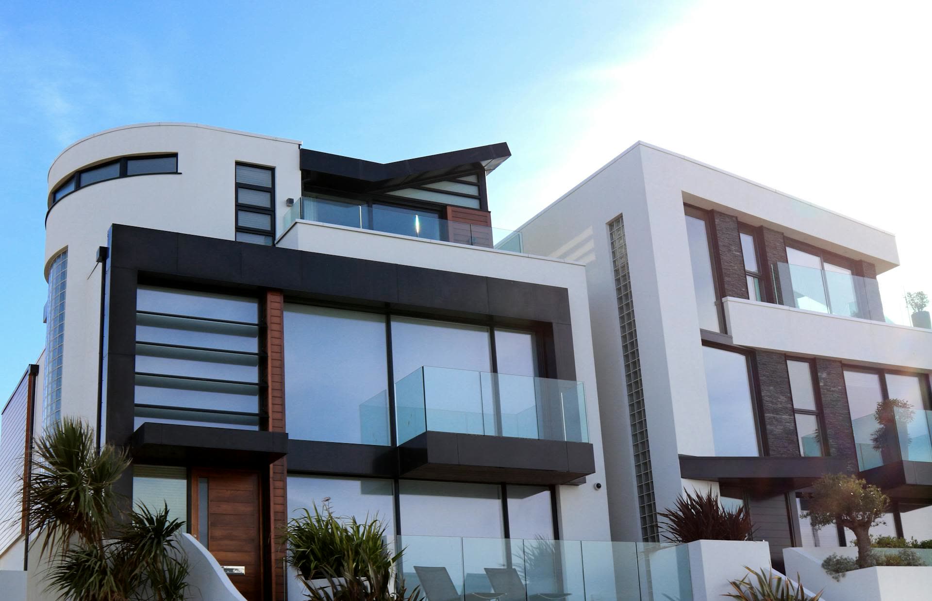 Modern brick and white-render duplex housing under a bright sky