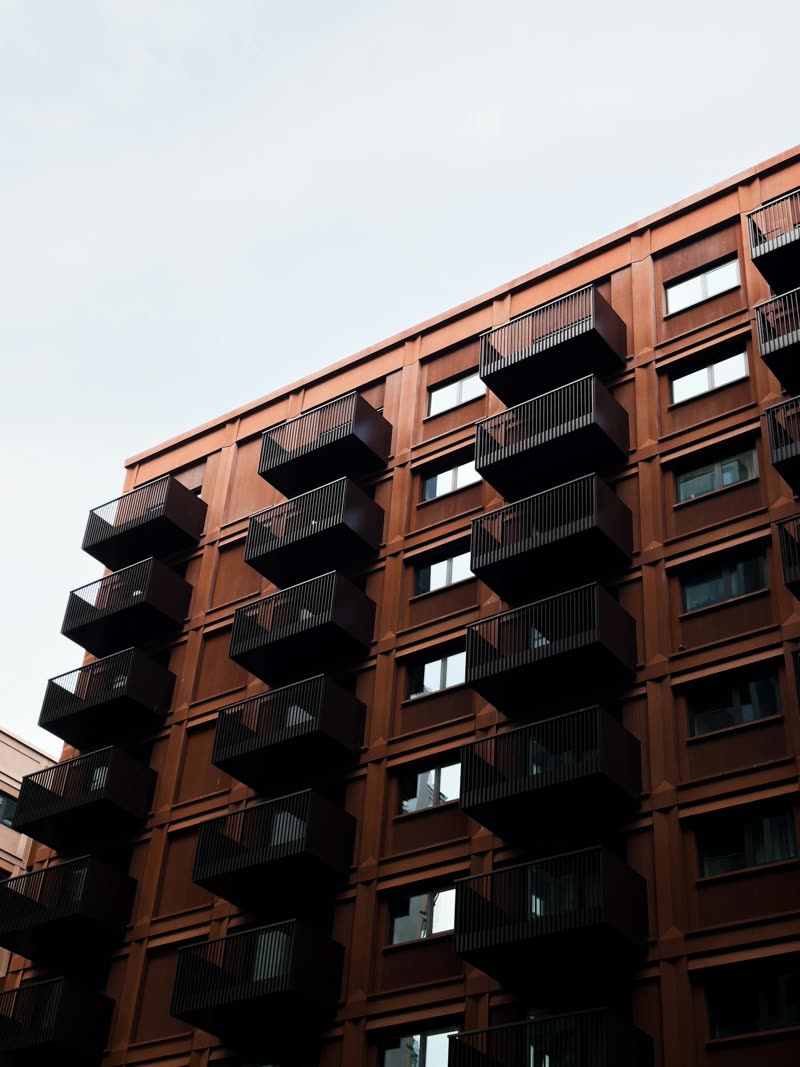 Four-storey mixed-use residential block with cantilevered balconies at practical completion